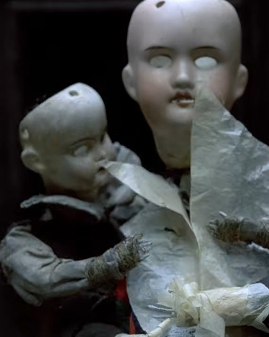 Two vintage dolls with a dark background