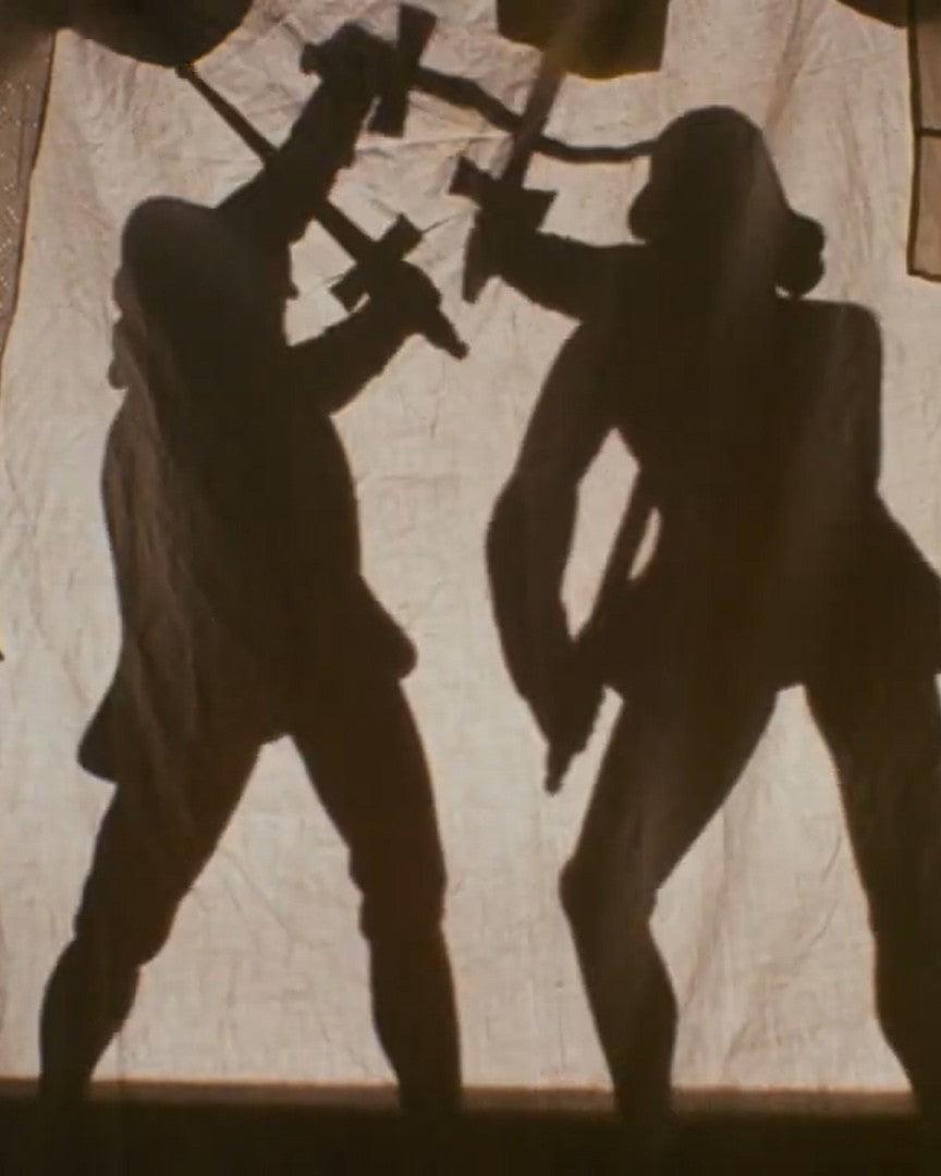 Shadow play of two figures with crossed swords on a textured wall.